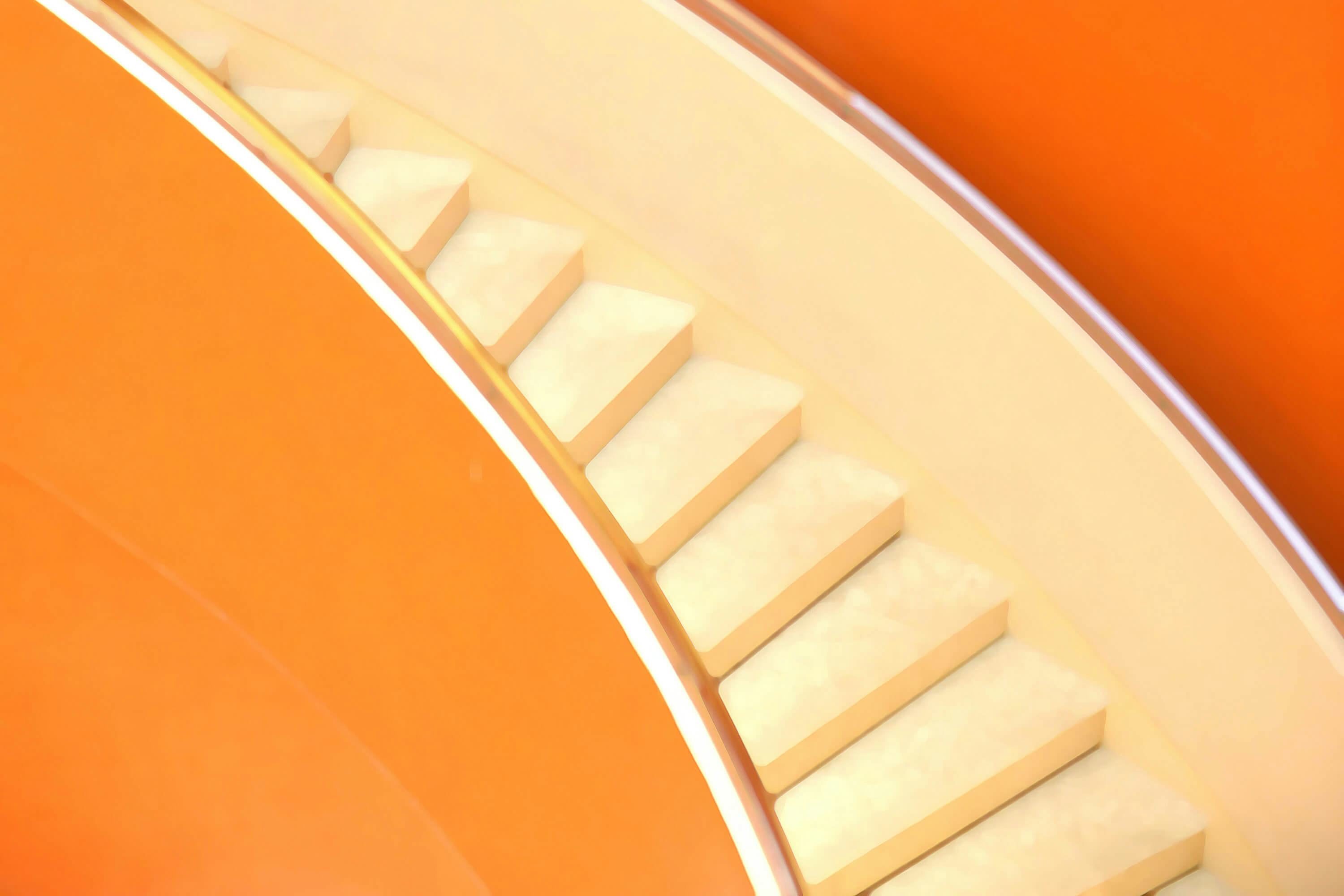 Abstract image - close-up of a notched golden ring against an orange background